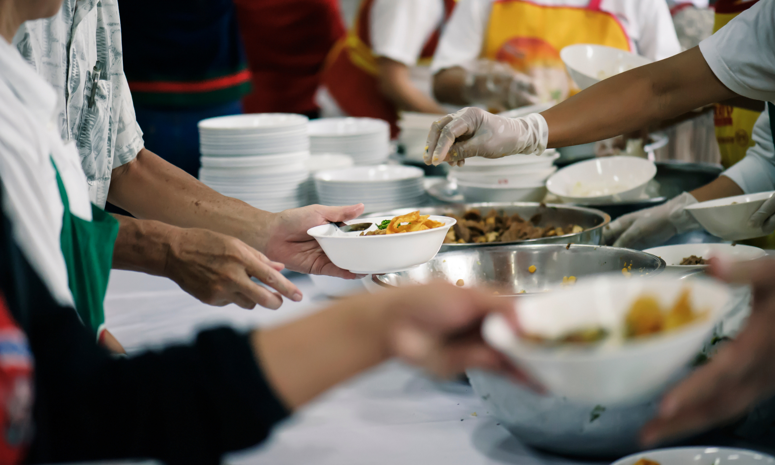 Hands serving food at a table